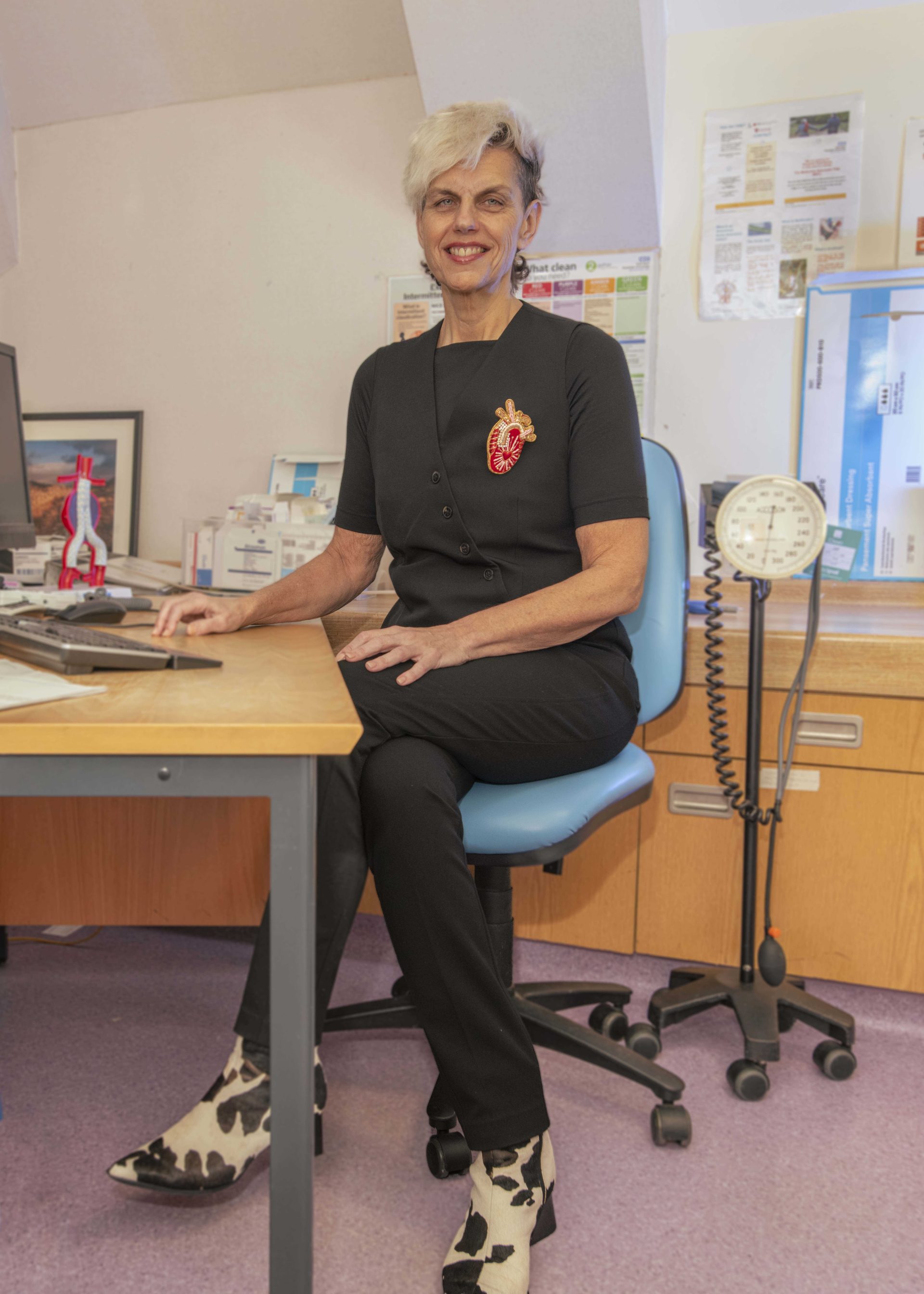 Individual in a black outfit, sitting in an outpatient clinic