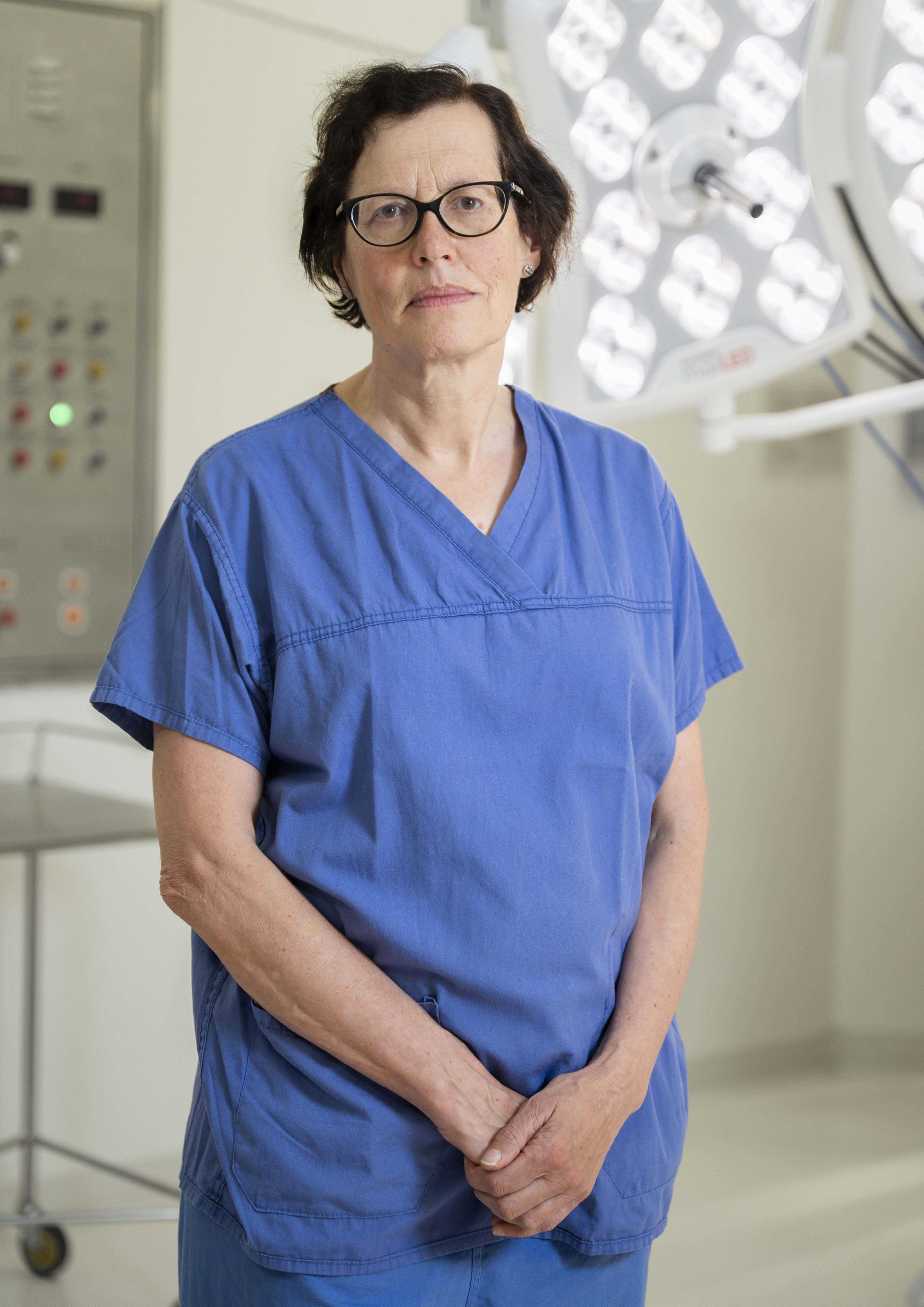 Individual in dark blue scrubs, standing in a surgical theatre