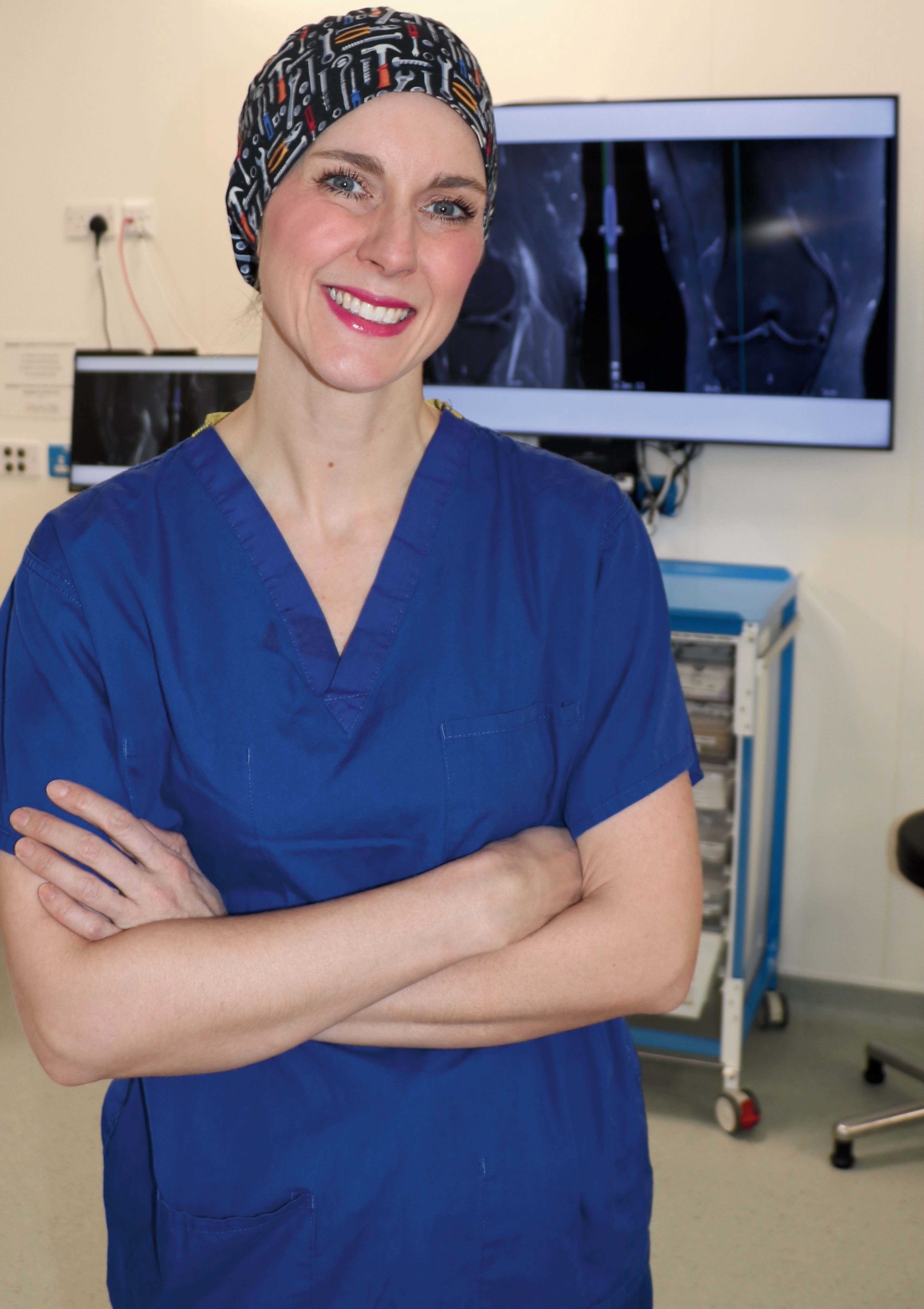 Individual in blue scrubs in a clinical room