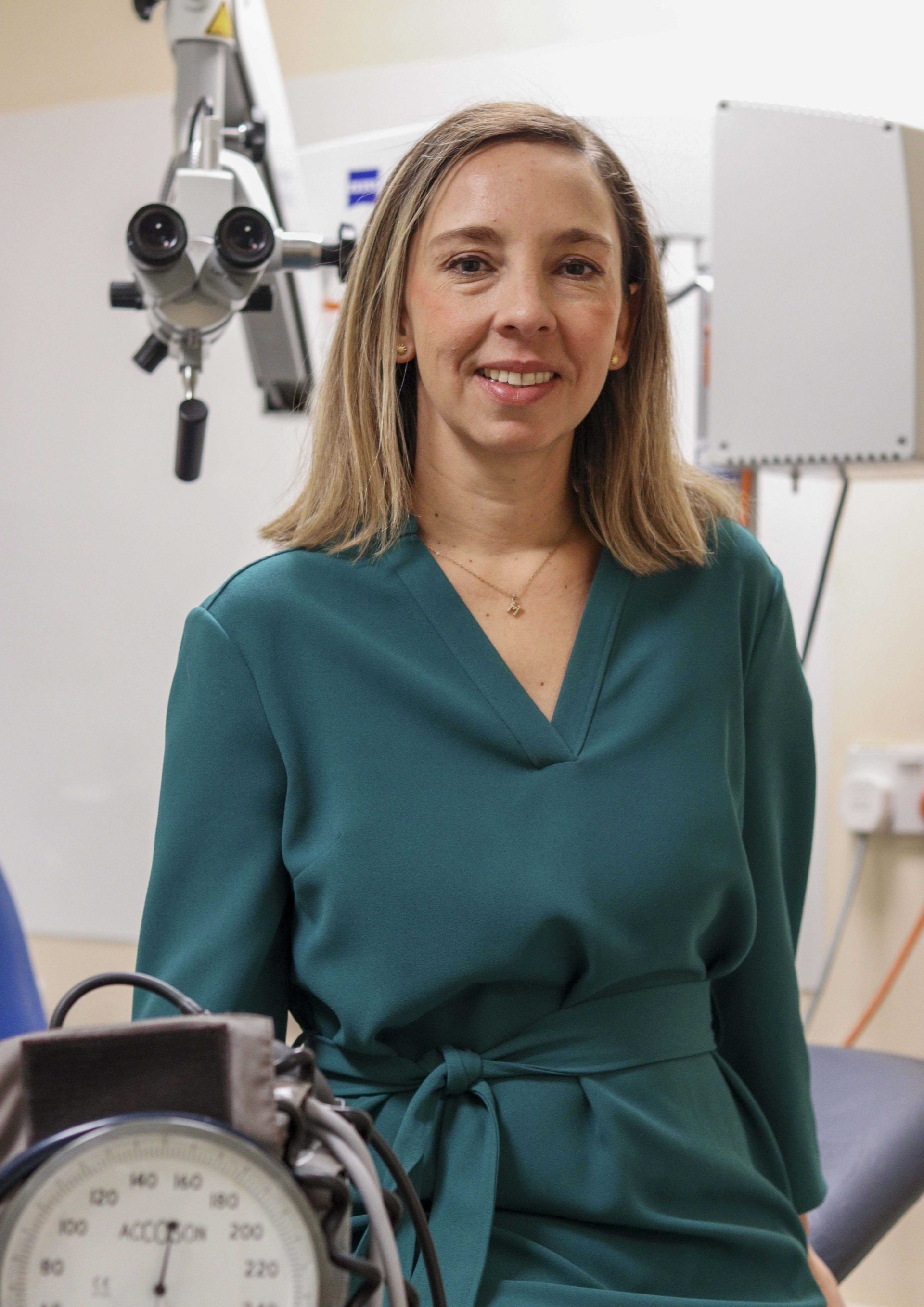 Individual wearing a green dress in a clinical room